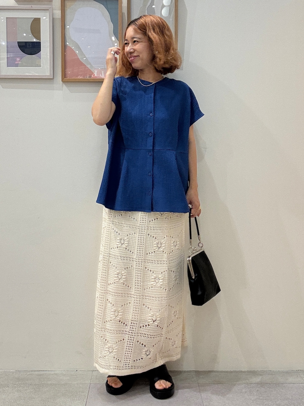 ブルー系のシャツ/ブラウス、ホワイト系のスカート、ブラック系のサンダルを着用したレディースの夏コーディネートの1枚目の写真