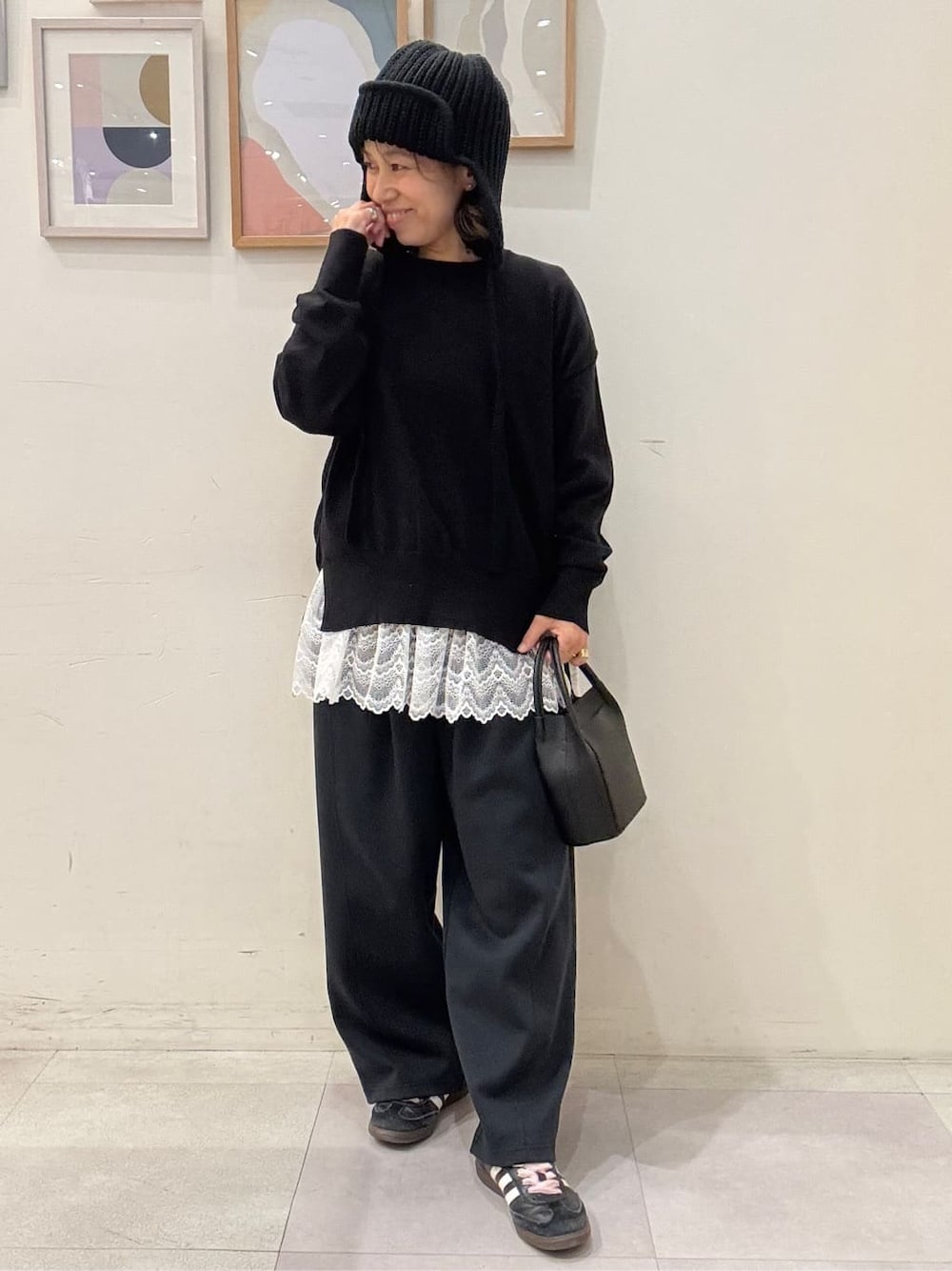 ブラック系のニット/セーター、ホワイト系のTシャツ/カットソー、ブラック系のその他パンツを着用したレディースの秋コーディネートの1枚目の写真