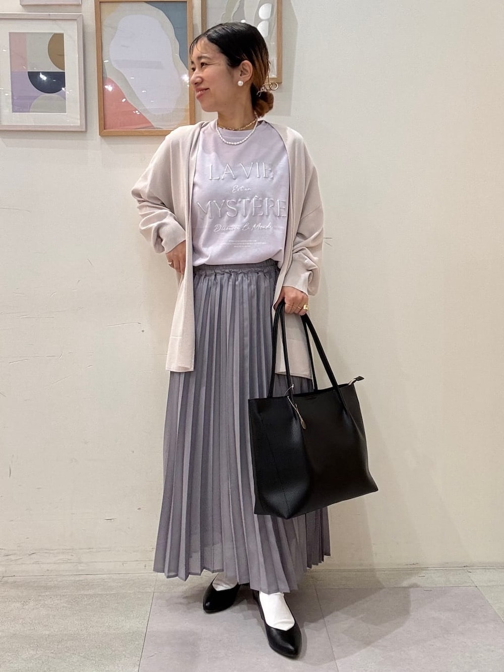 ベージュ系のカーディガン/ボレロ、パープル系のTシャツ/カットソー、グレー系のスカートを着用したレディースの春コーディネートの1枚目の写真
