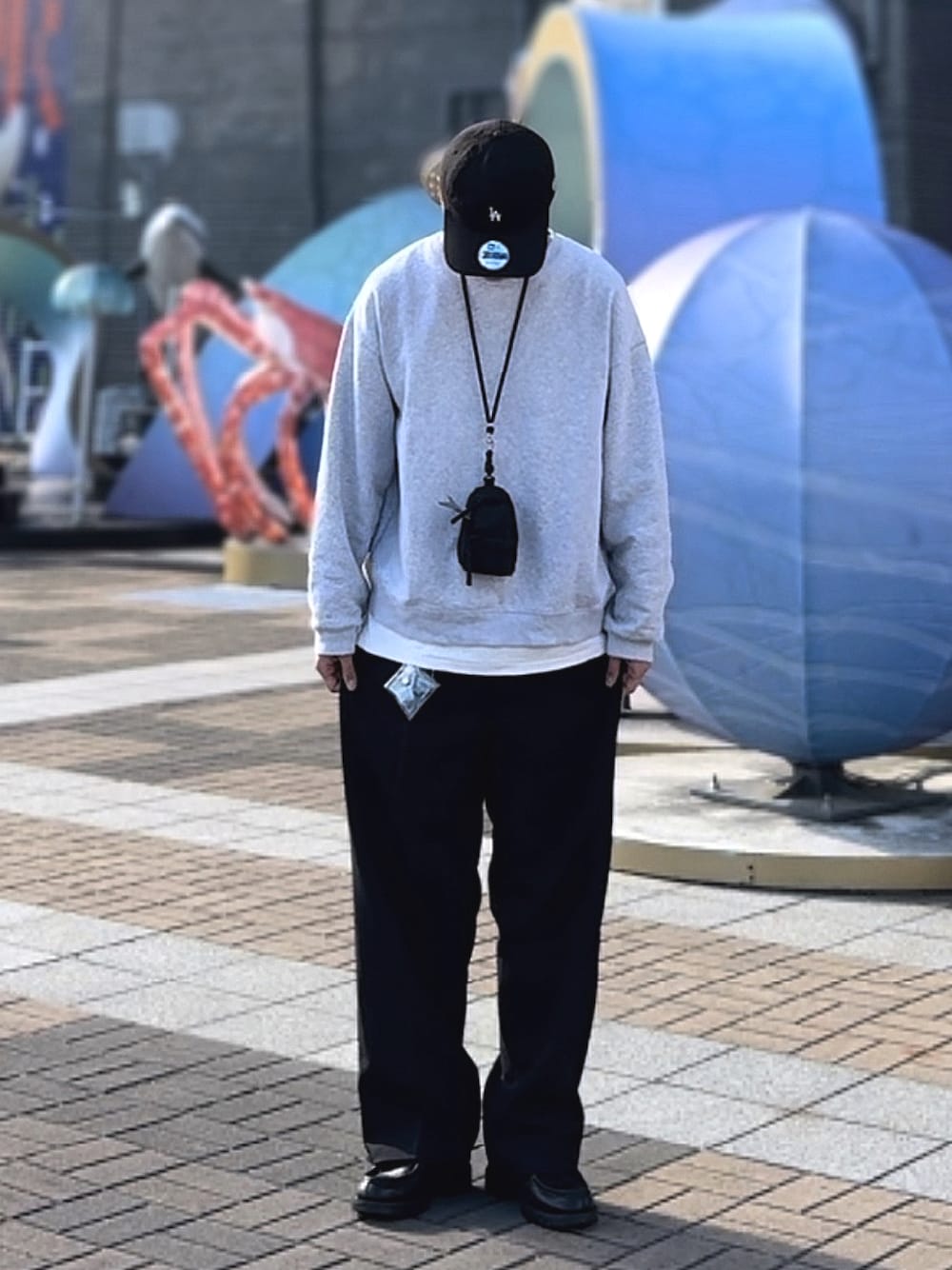 グレー系のスウェット、ブラック系のスラックス、ブラック系のその他シューズを着用したメンズの冬コーディネートの1枚目の写真