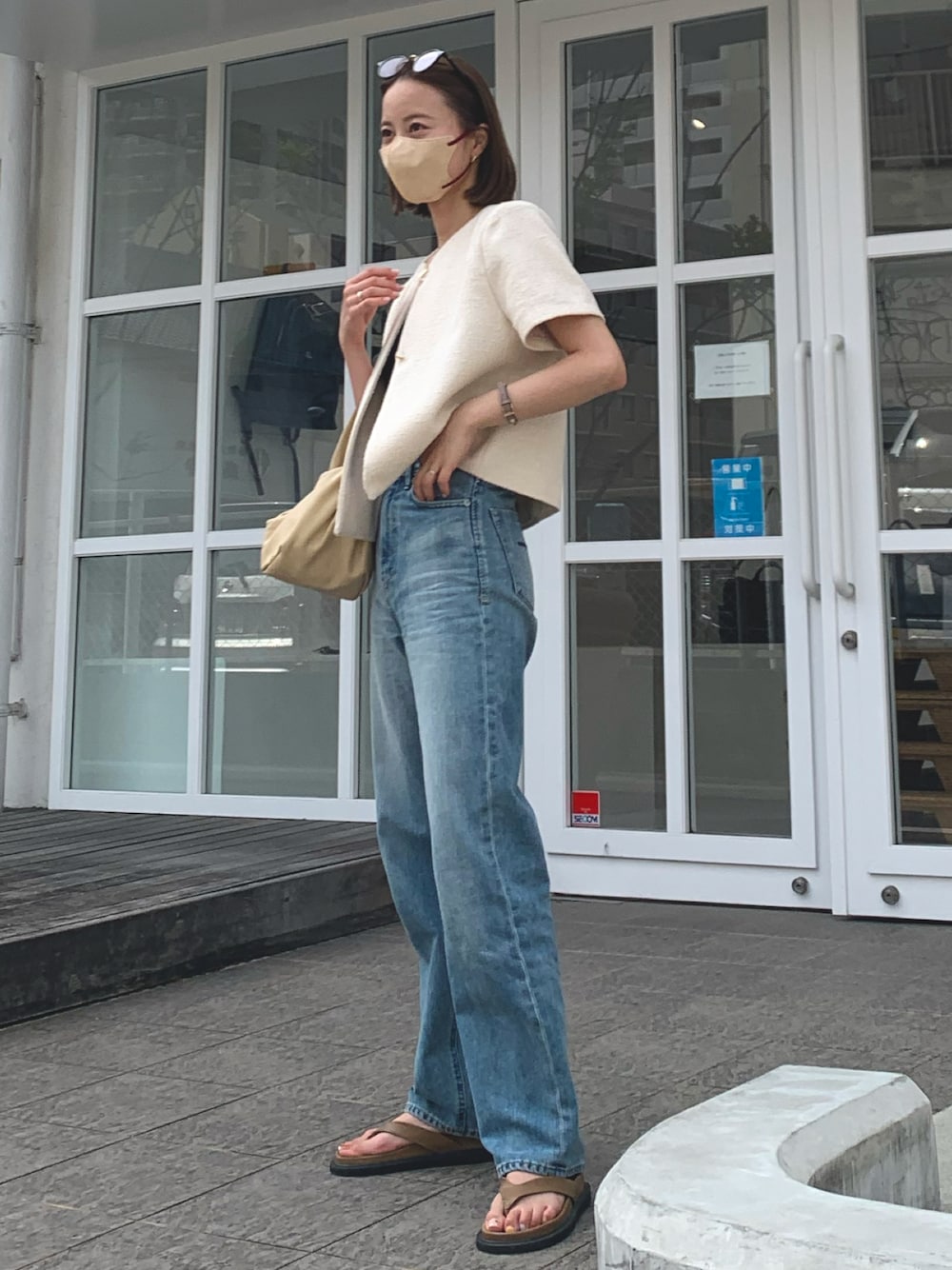 ホワイト系のジャケット/アウター、ブルー系のデニムパンツ、ベージュ系のハンドバッグを着用したレディースの夏コーディネートの1枚目の写真