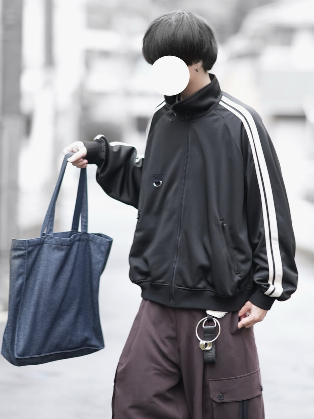 ブラック系のジャージ、ブルー系のトートバッグ、ブラウン系のカーゴパンツを着用したメンズの冬コーディネートの1枚目の写真