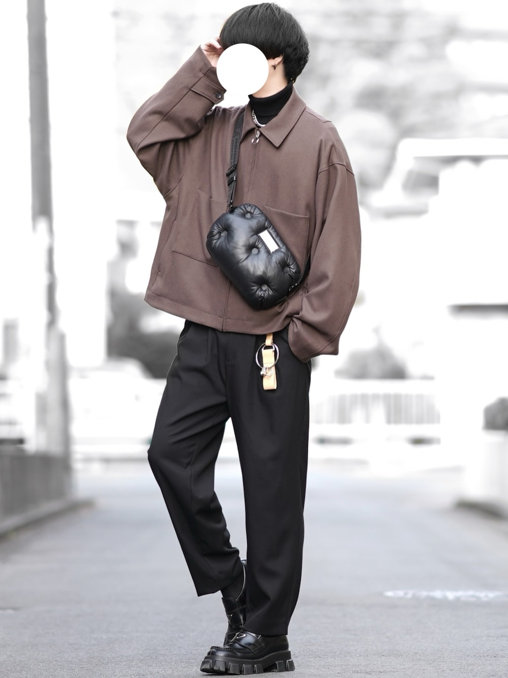 ブラウン系のブルゾン、ブラック系のニット/セーター、ブラック系のスラックスを着用したメンズの冬コーディネートの1枚目の写真