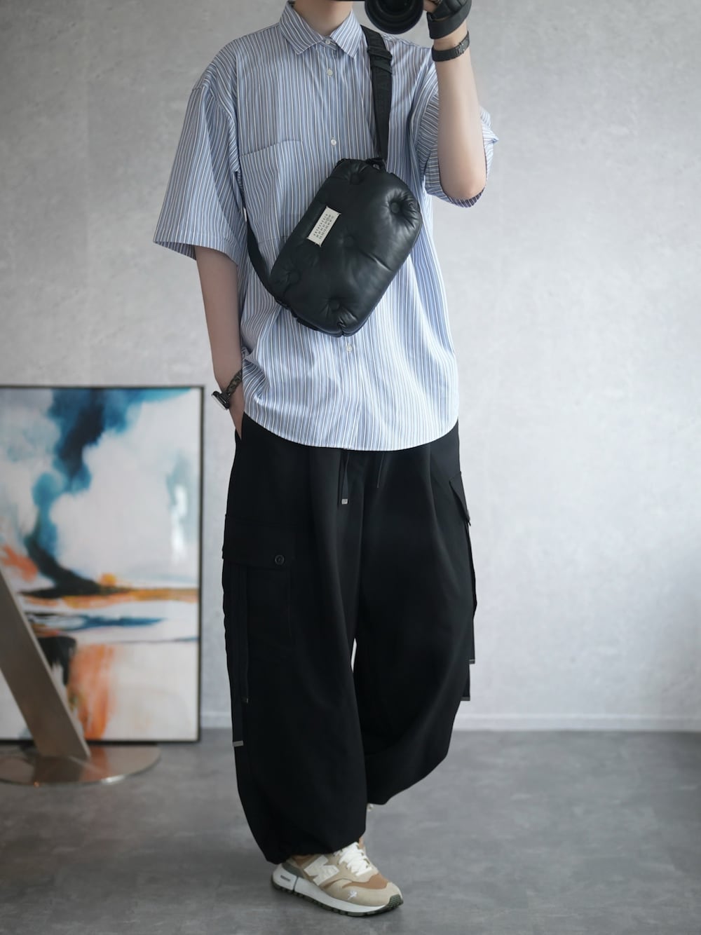 ブルー系のシャツ/ブラウス、ブラック系のカーゴパンツ、ベージュ系のスニーカーを着用したメンズの夏コーディネートの1枚目の写真