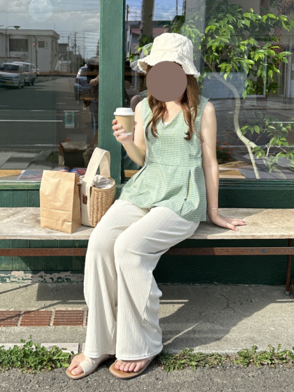 ベージュ系のかごバッグ、ベージュ系のパンツ、ベージュ系のサンダルを着用したレディースの夏コーディネートの1枚目の写真