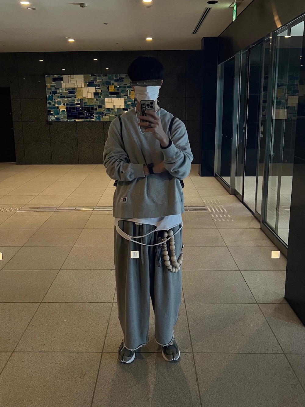 グレー系のスニーカー、グレー系のスウェットパンツ、ホワイト系のTシャツ/カットソーを着用したメンズの冬コーディネートの1枚目の写真