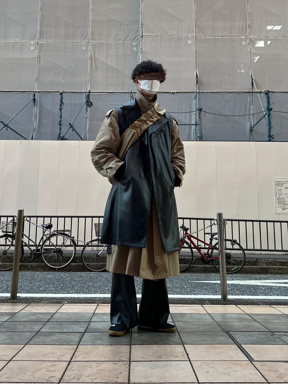 ブラック系のスニーカー、ブラック系のその他パンツ、ベージュ系のトレンチコートを着用したメンズの冬コーディネートの1枚目の写真