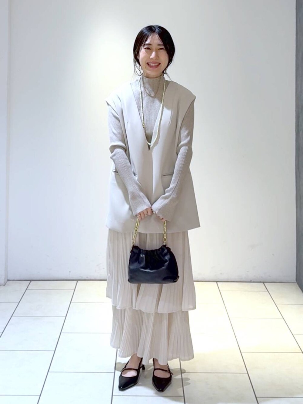 ホワイト系のスカート、ベージュ系のスーツセット、ホワイト系のニット/セーターを着用したレディースの冬コーディネートの1枚目の写真