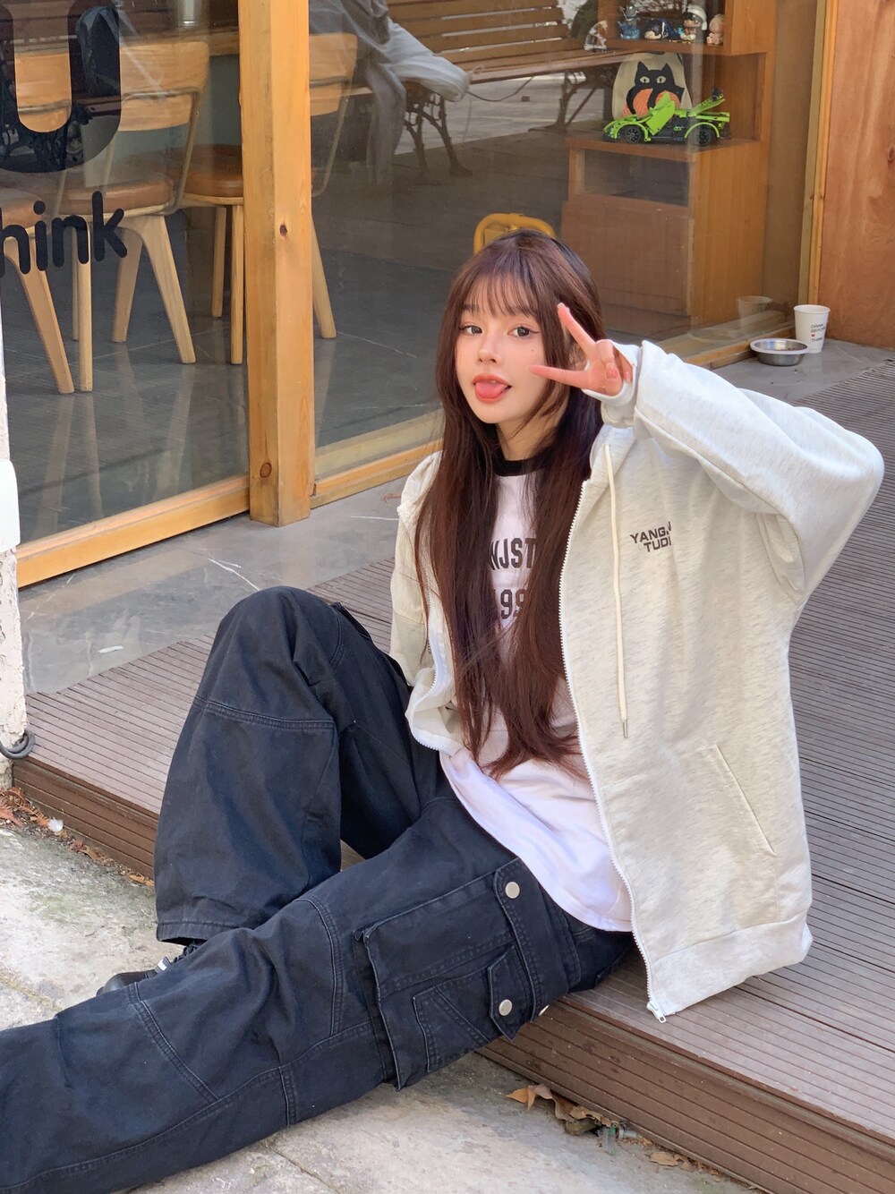 ベージュ系のパーカーを着用したレディースの冬コーディネートの1枚目の写真