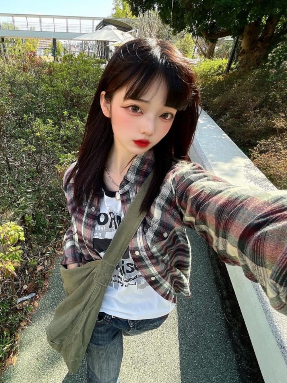 グリーン系のショルダーバッグを着用したレディースの春コーディネートの1枚目の写真