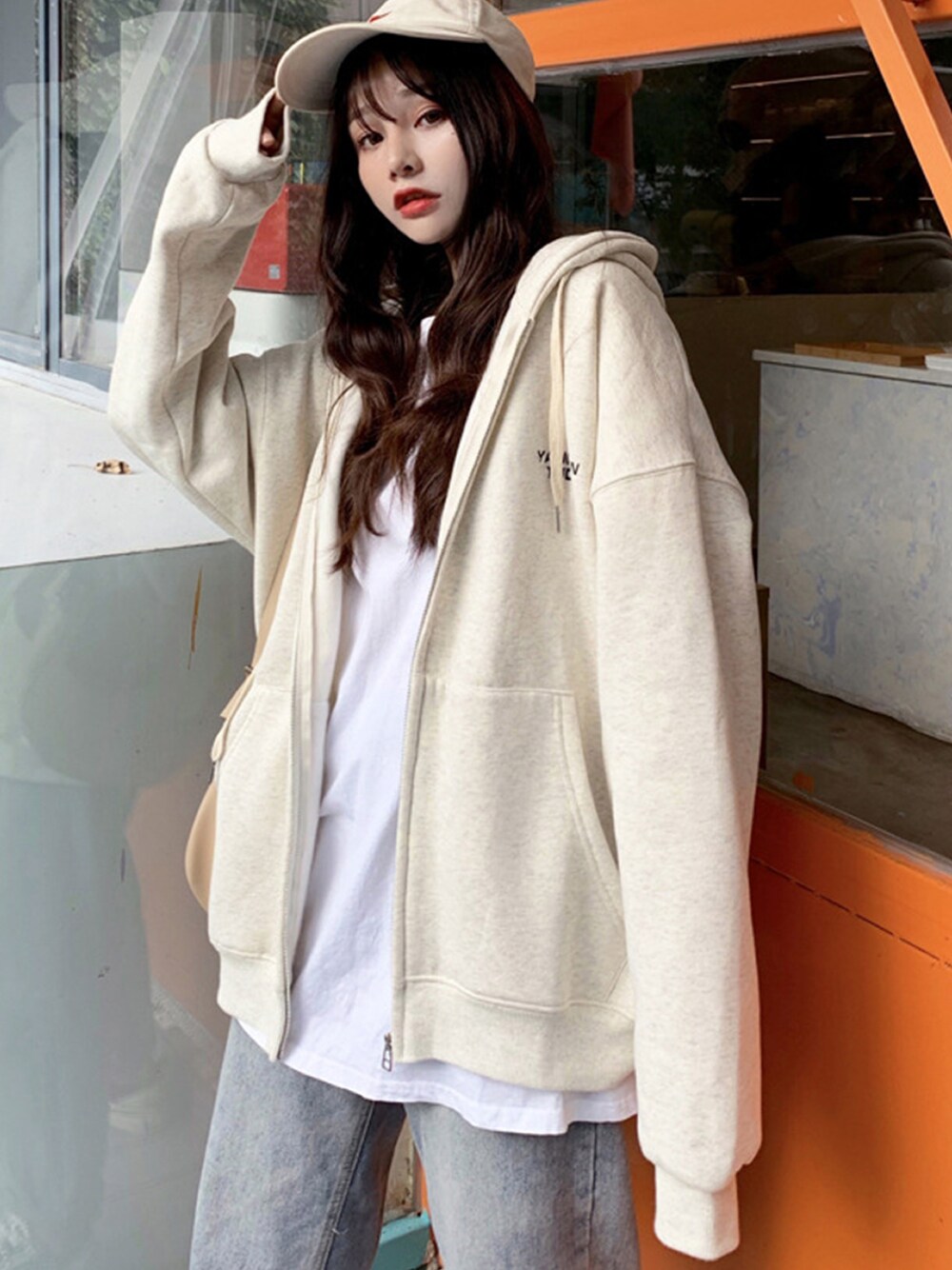 ベージュ系のパーカーを着用したレディースの冬コーディネートの1枚目の写真