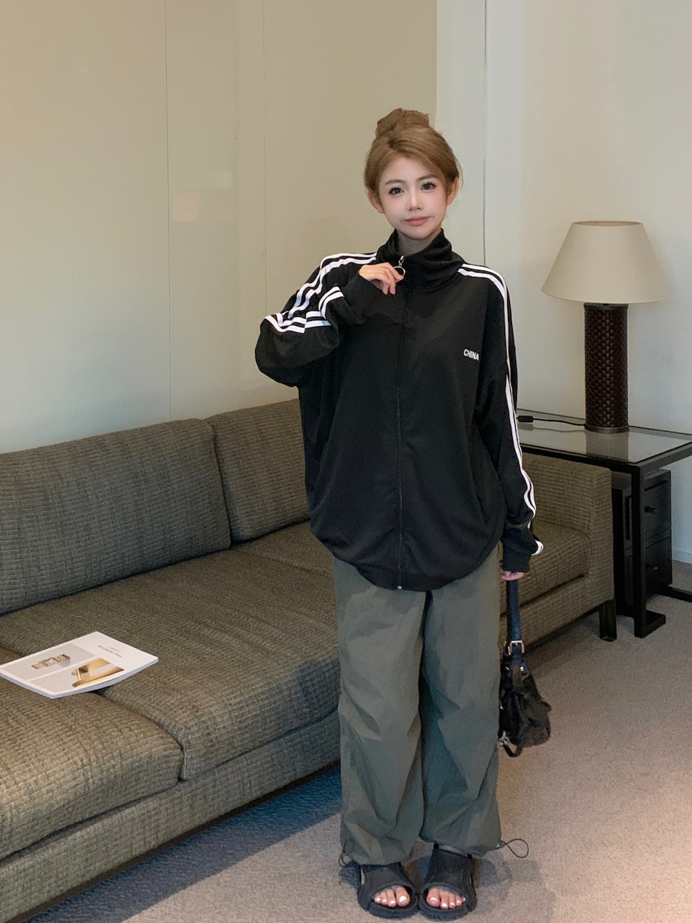 ブラック系のジャージを着用したレディースの秋コーディネートの1枚目の写真