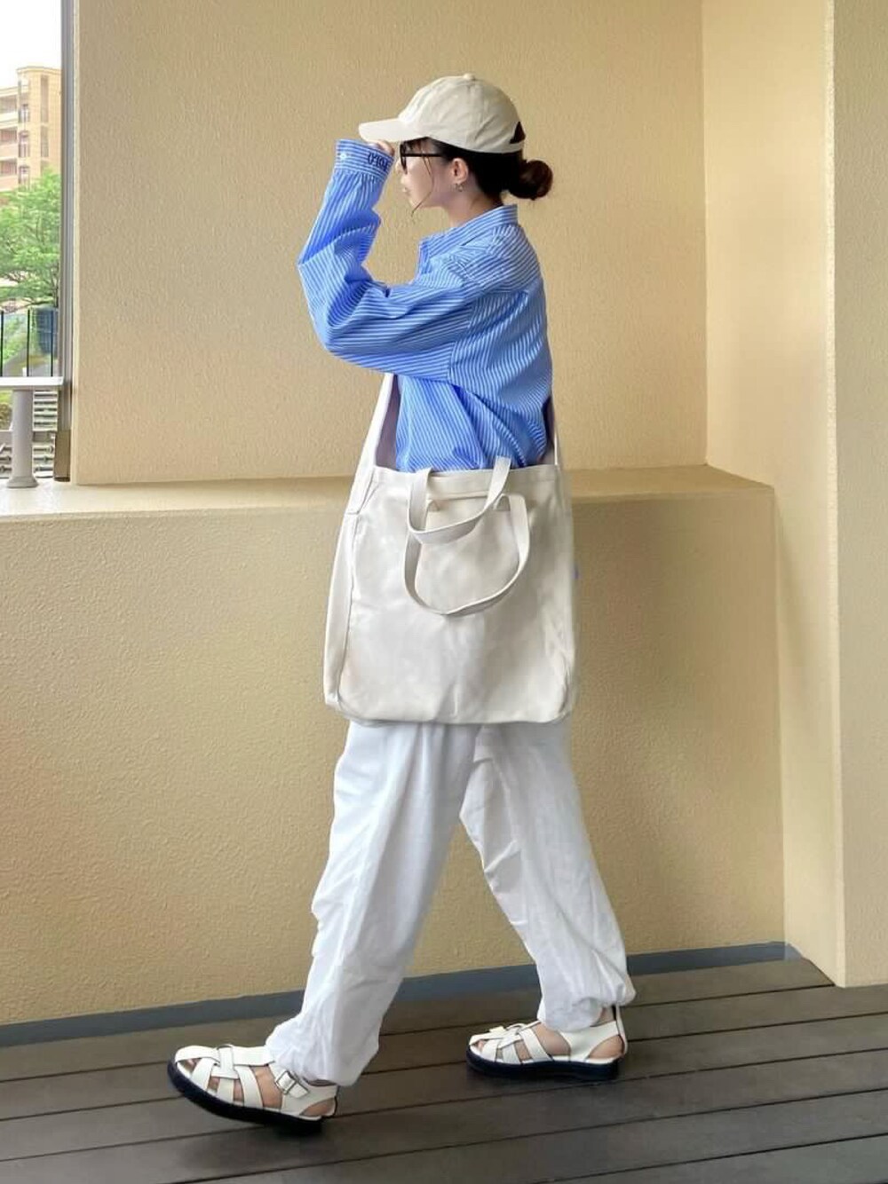 ベージュ系のショルダーバッグを着用したレディースの夏コーディネートの1枚目の写真