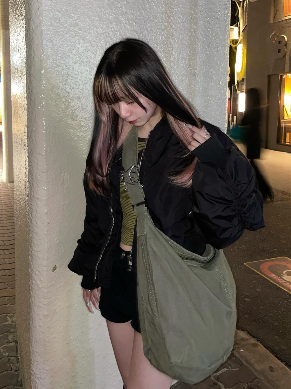 グリーン系のショルダーバッグを着用したレディースの春コーディネートの1枚目の写真