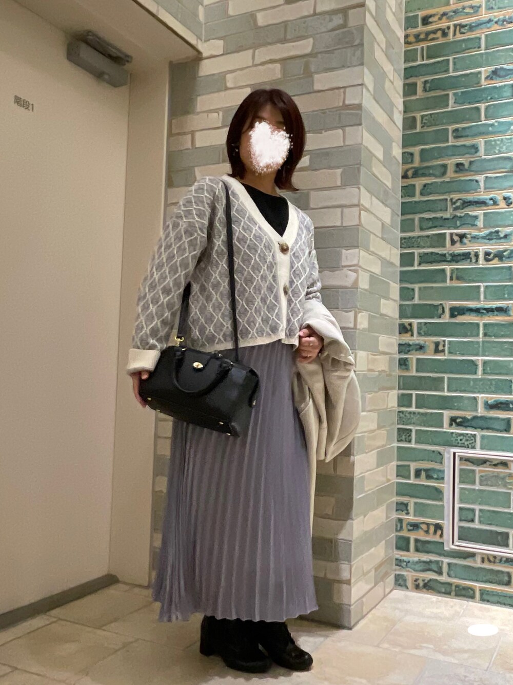 パープル系のカーディガン/ボレロ、パープル系のスカート、ブラック系のブーツを着用したレディースの冬コーディネートの1枚目の写真