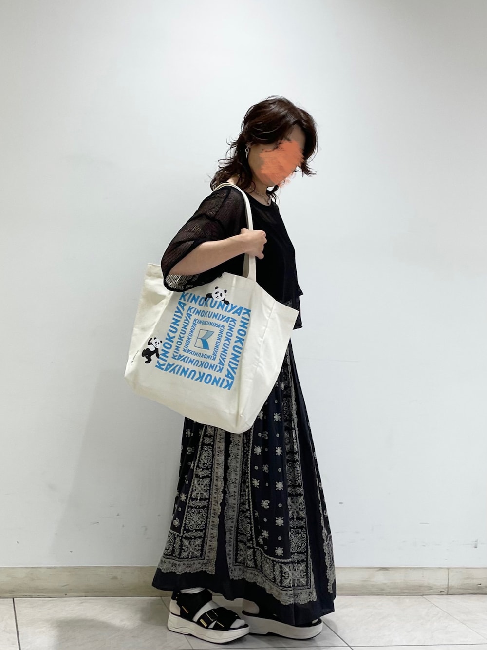ブラック系のニット/セーター、ブラック系のタンクトップ、グレー系のスカートを着用したレディースの夏コーディネートの1枚目の写真