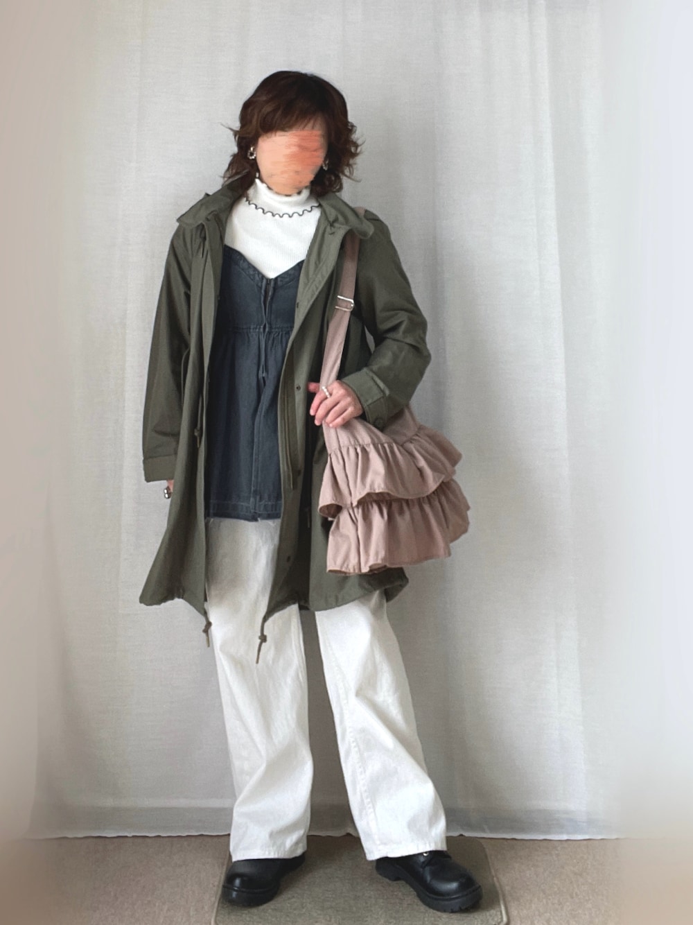ピンク系のショルダーバッグ、ホワイト系のデニムパンツ、グリーン系のモッズコートを着用したレディースの冬コーディネートの1枚目の写真