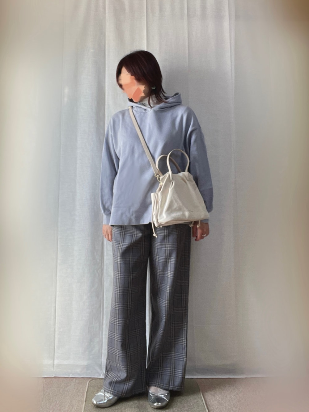 ブルー系のパーカー、グレー系のパンツ、シルバー系のバレエシューズを着用したレディースの春コーディネートの1枚目の写真