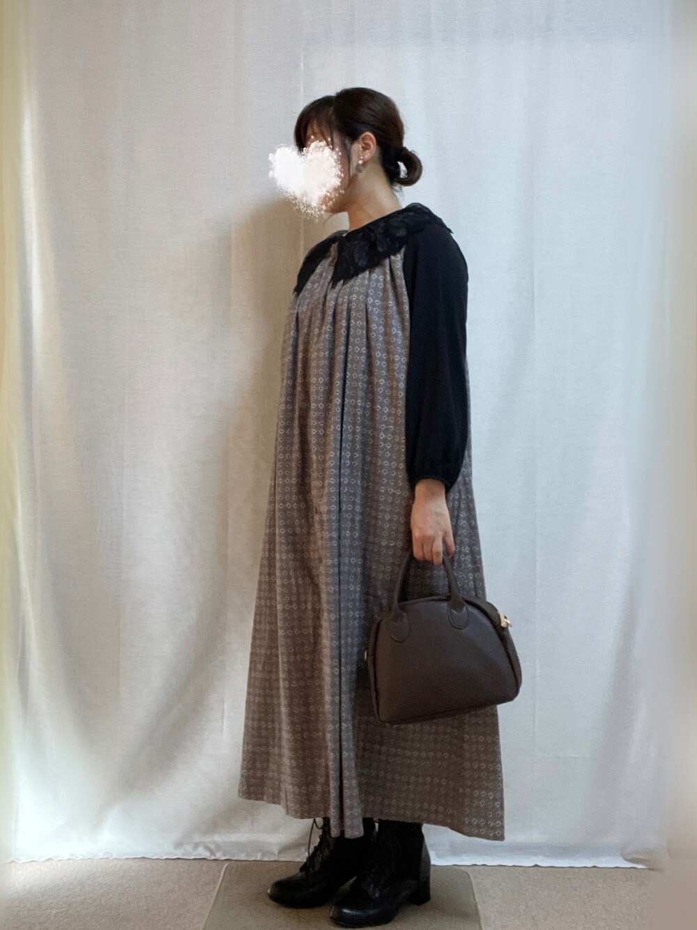 ブラウン系のボストンバッグ、グレー系のワンピース、ブラック系のブーツを着用したレディースの秋コーディネートの1枚目の写真