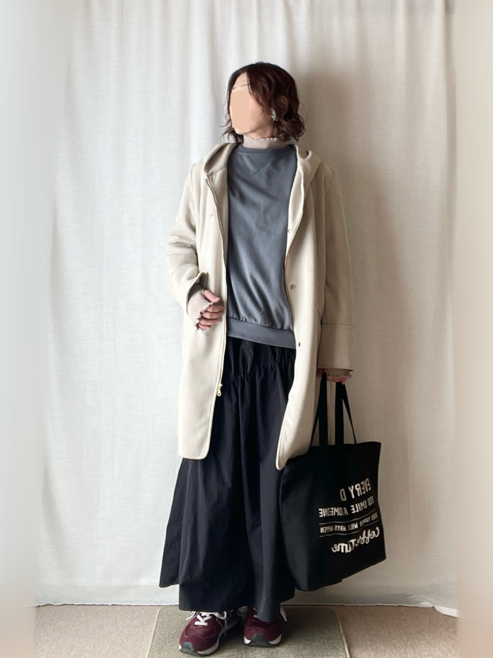 ブルー系のスウェット、ベージュ系のニット/セーター、ブラック系のスカートを着用したレディースの春コーディネートの1枚目の写真