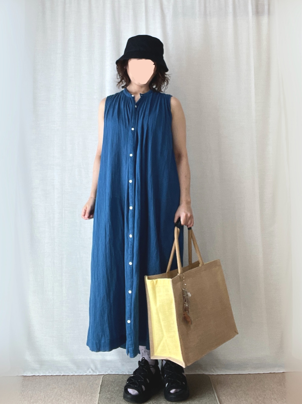 ブルー系のワンピース、ブラック系のサンダル、ベージュ系のトートバッグを着用したレディースの夏コーディネートの1枚目の写真