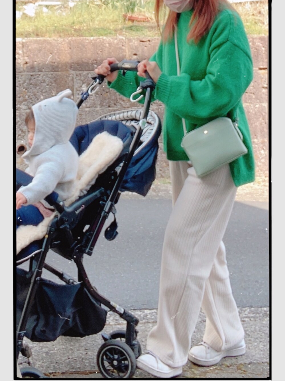 ホワイト系のスニーカー、グリーン系のニット/セーター、ホワイト系のパンツを着用したレディースの春コーディネートの1枚目の写真