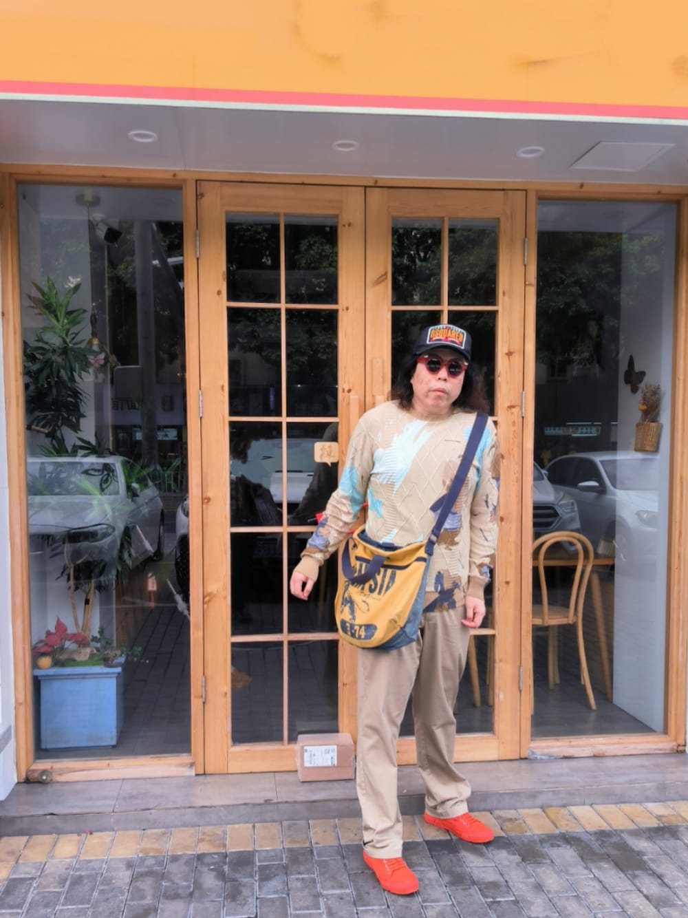 ベージュ系のパンツ、オレンジ系のシューズ、ベージュ系のニット/セーターを着用したメンズの冬コーディネートの1枚目の写真