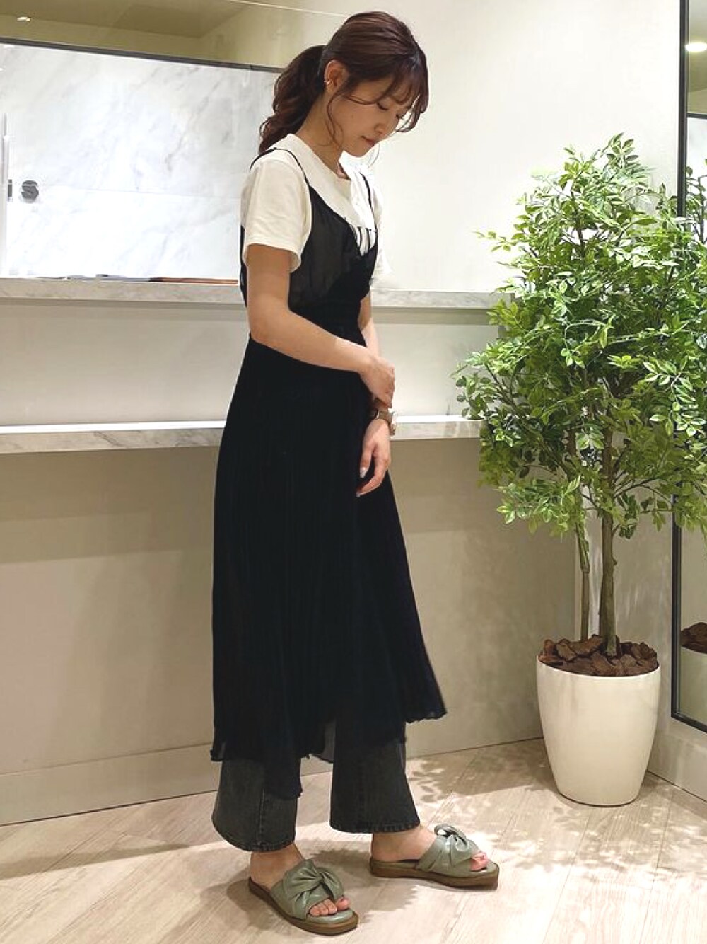 グリーン系のサンダルを着用したレディースの春コーディネートの1枚目の写真