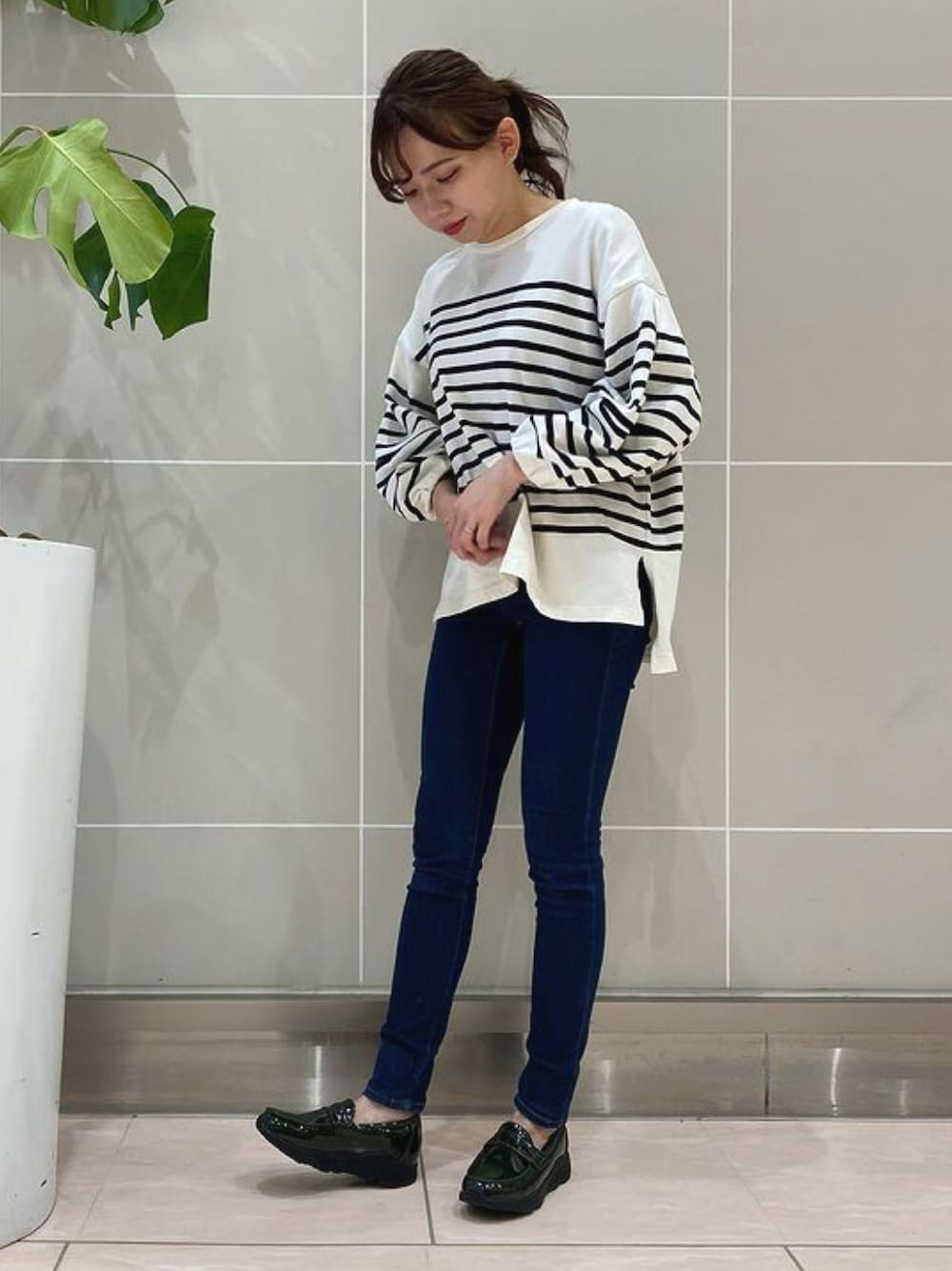 グリーン系のローファーを着用したレディースの秋コーディネートの1枚目の写真