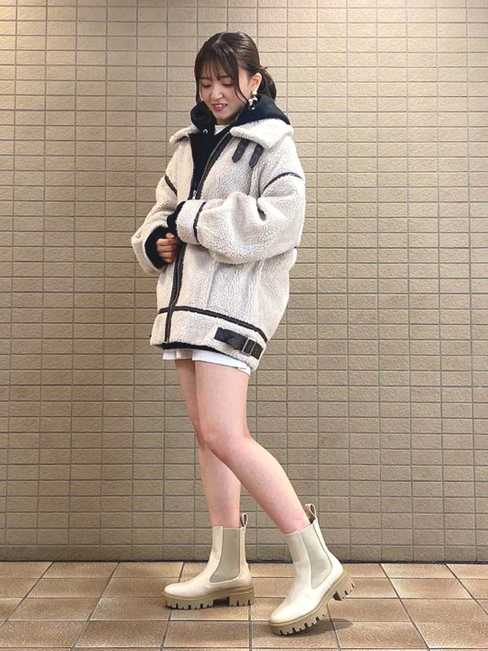 ホワイト系のブーツを着用したレディースの冬コーディネートの1枚目の写真