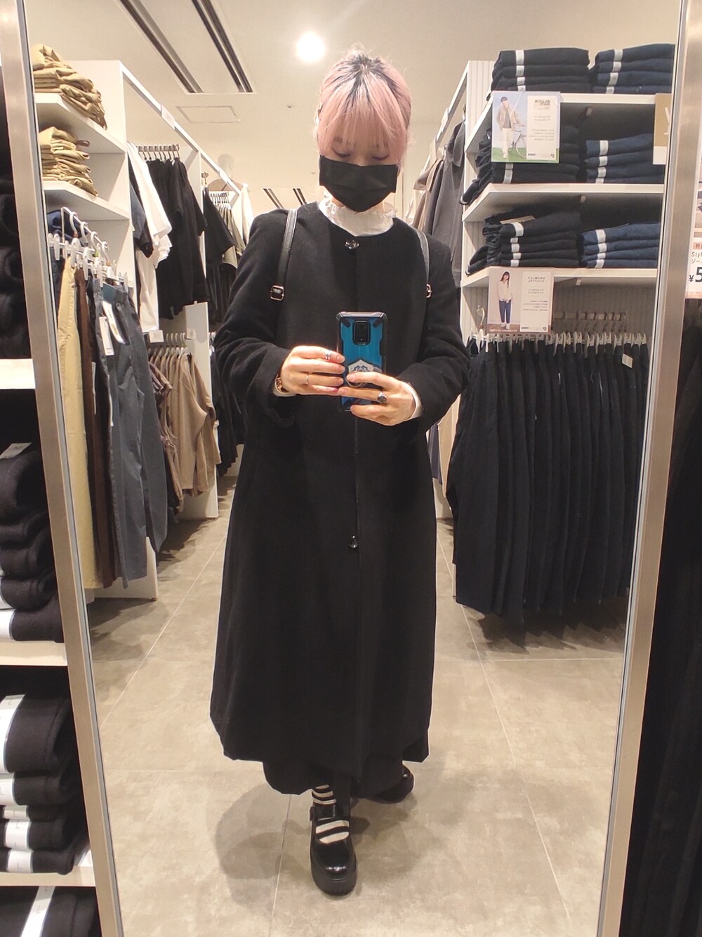 ブラック系のシューズ、ホワイト系のシャツ/ブラウス、ブラック系のジャンパースカートを着用したレディースの冬コーディネートの3枚目の写真