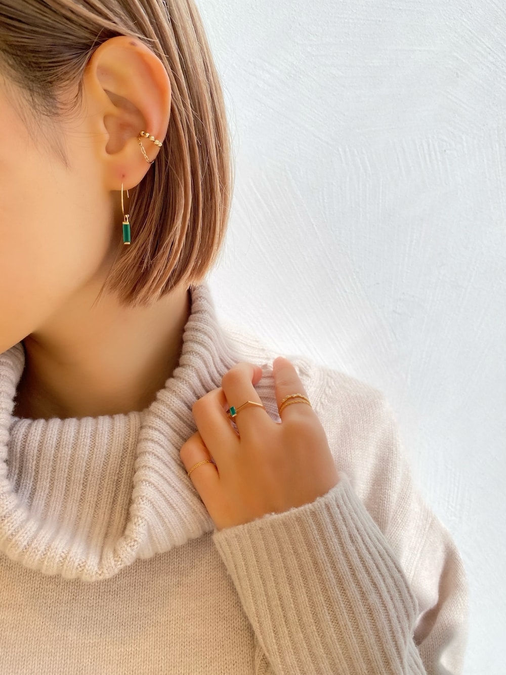 ゴールド系のイヤーカフ、ゴールド系のピアス（両耳用）、ゴールド系のリングを着用したレディースの冬コーディネートの1枚目の写真