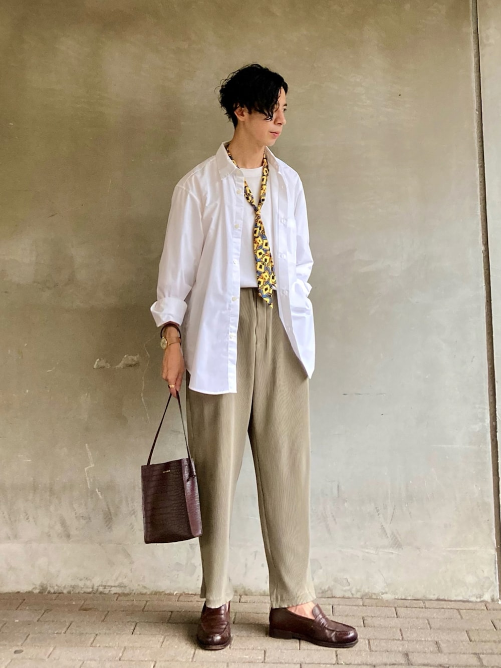 グリーン系のパンツ、ブラウン系のショルダーバッグ、ブラック系のシャツ/ブラウスを着用したメンズの秋コーディネートの1枚目の写真