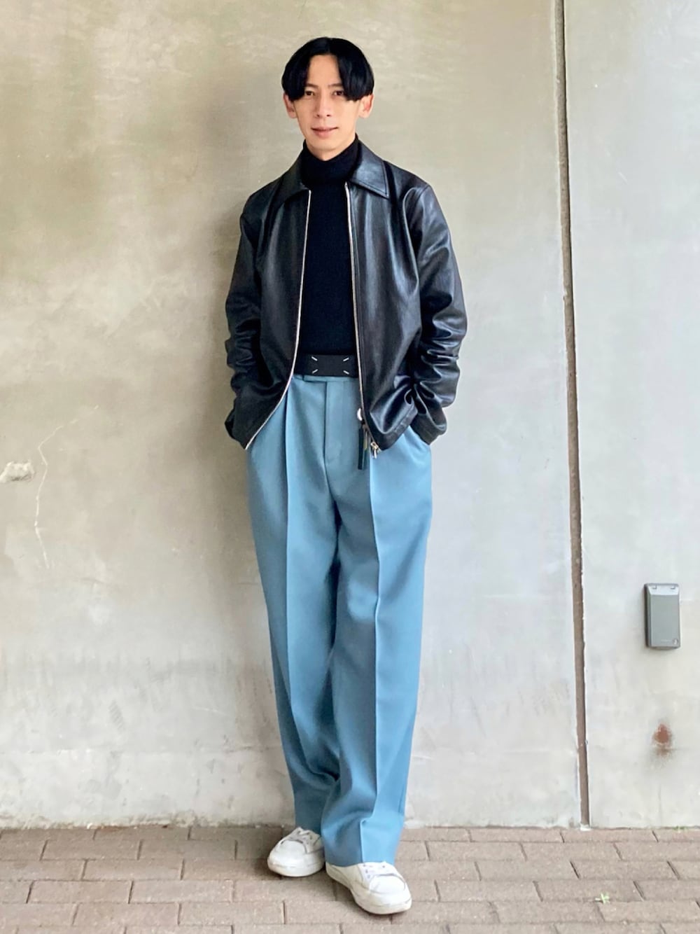 ブラウン系のニット/セーター、ブルー系のスラックス、ホワイト系のスニーカーを着用したメンズの秋コーディネートの1枚目の写真