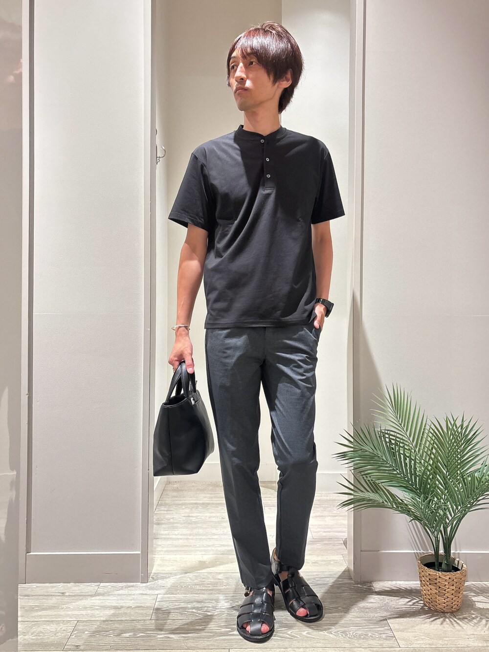 ブラック系のTシャツ/カットソー、グレー系のスラックス、ブラック系のトートバッグを着用したメンズの夏コーディネートの1枚目の写真