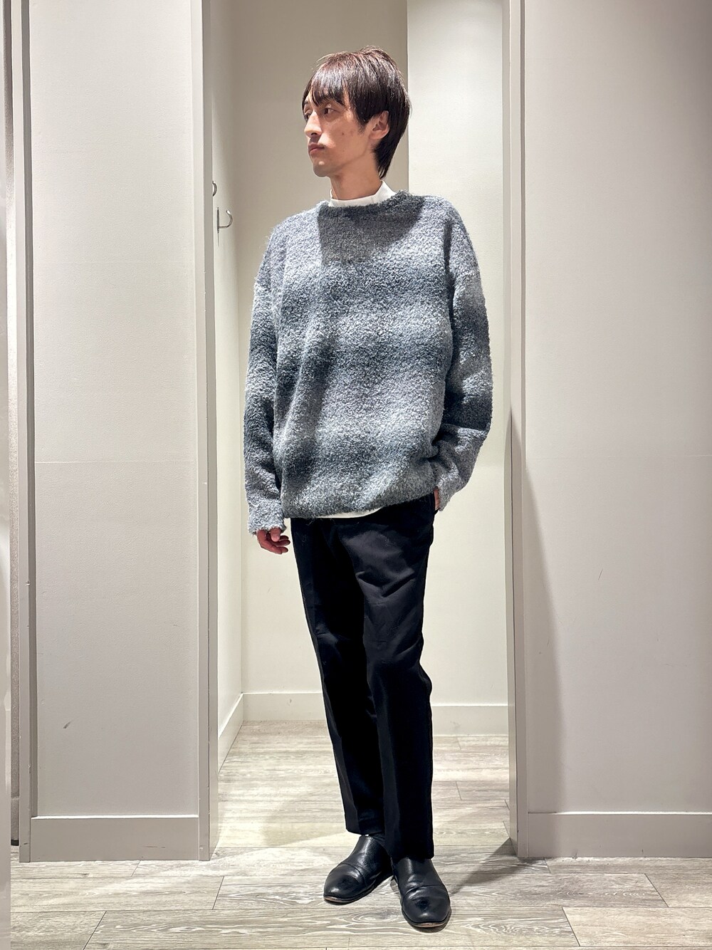 ブラック系のニット/セーター、ホワイト系のTシャツ/カットソー、ブラック系のチノパンツを着用したメンズの秋コーディネートの1枚目の写真