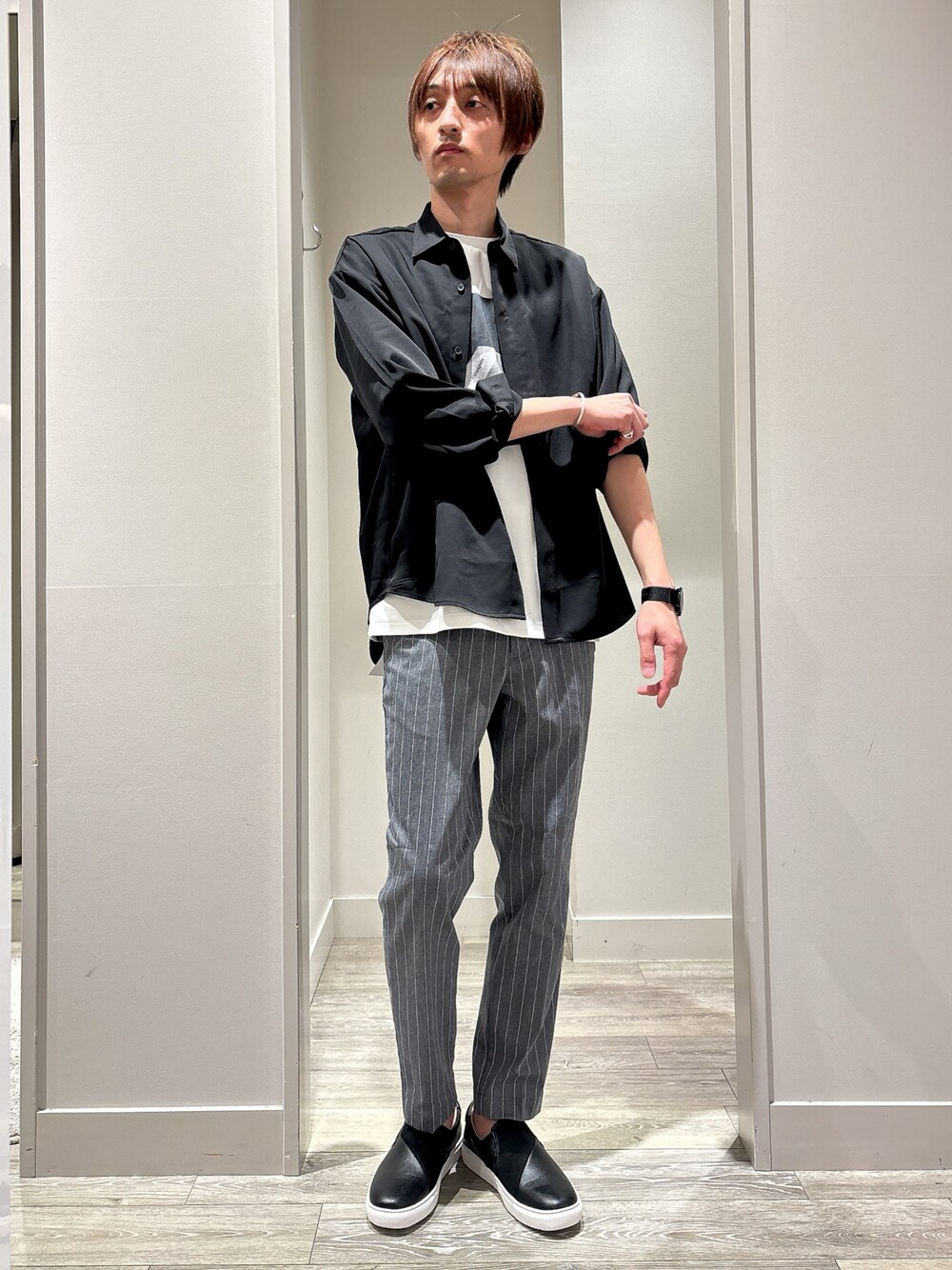 ブラック系のシャツ/ブラウス、グレー系のスラックス、ホワイト系のTシャツ/カットソーを着用したメンズの春コーディネートの1枚目の写真