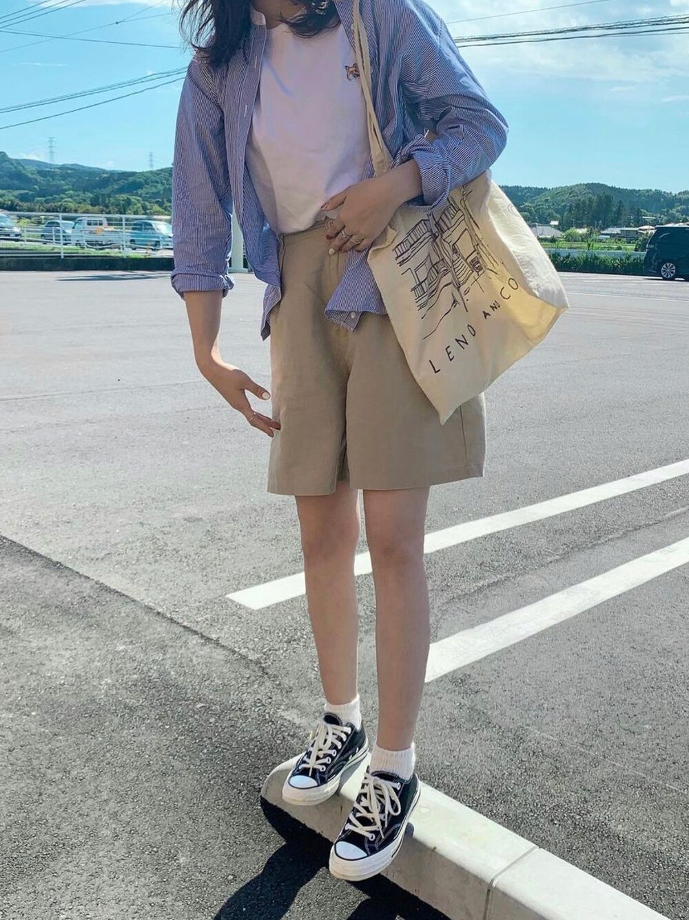 ホワイト系のTシャツ/カットソー、ホワイト系のトートバッグ、ブルー系のシャツ/ブラウスを着用したレディースの夏コーディネートの1枚目の写真
