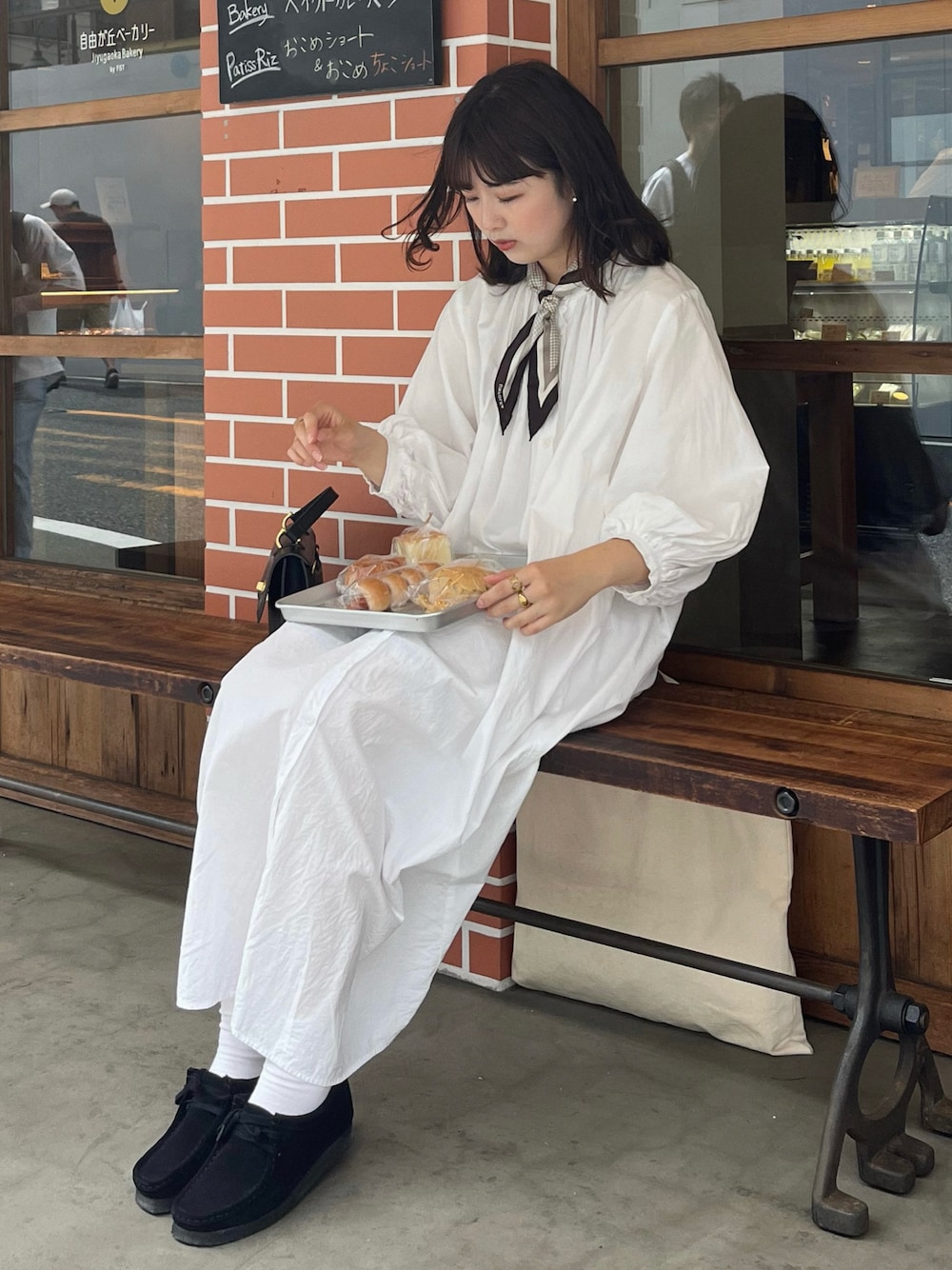 ホワイト系のワンピース、ブラック系のショルダーバッグ、ブラック系のモカシン/デッキシューズを着用したレディースの春コーディネートの1枚目の写真