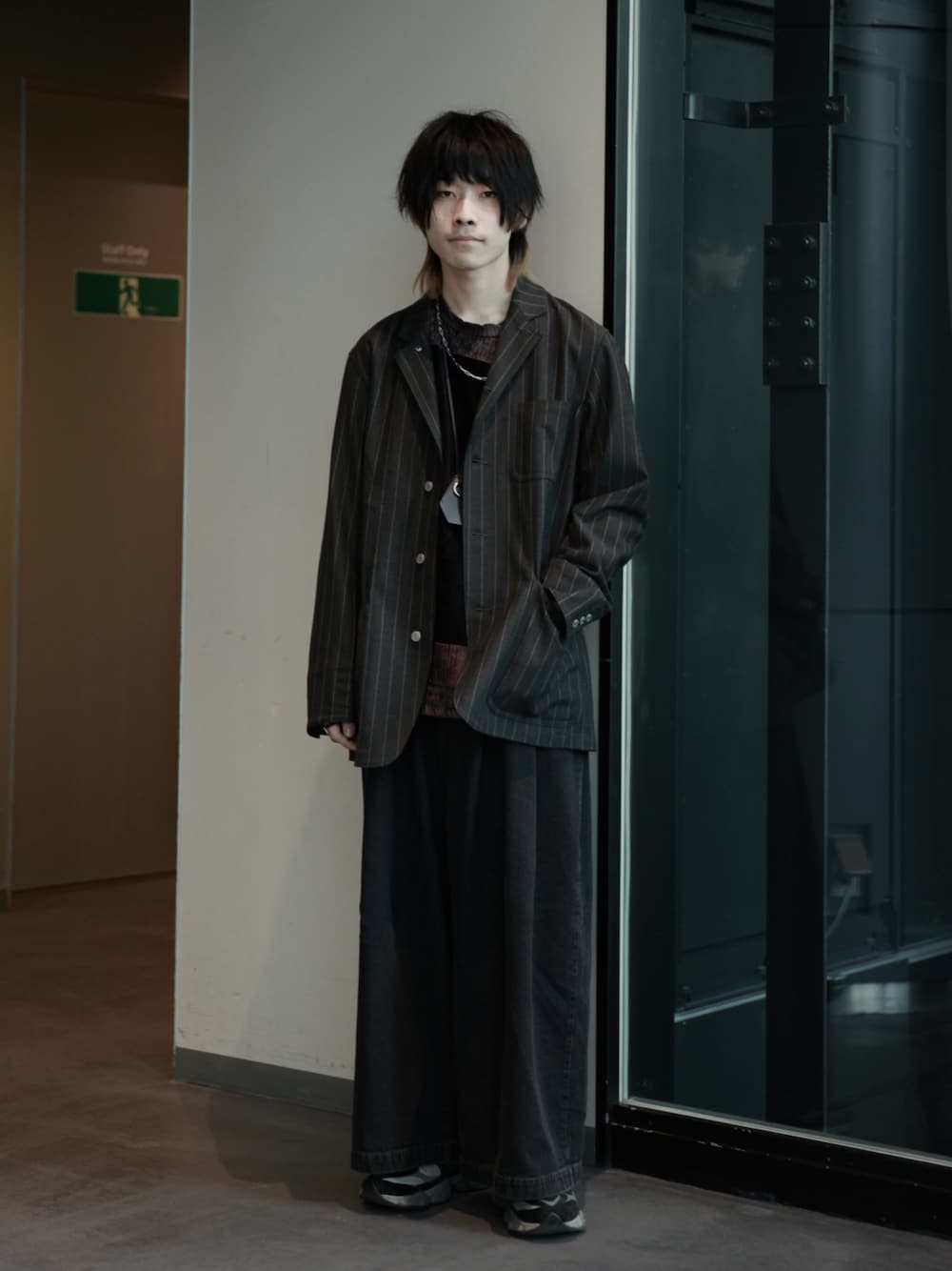 グレー系のカバーオール、ブラウン系のTシャツ/カットソー、ブルー系のデニムパンツを着用したメンズの冬コーディネートの1枚目の写真