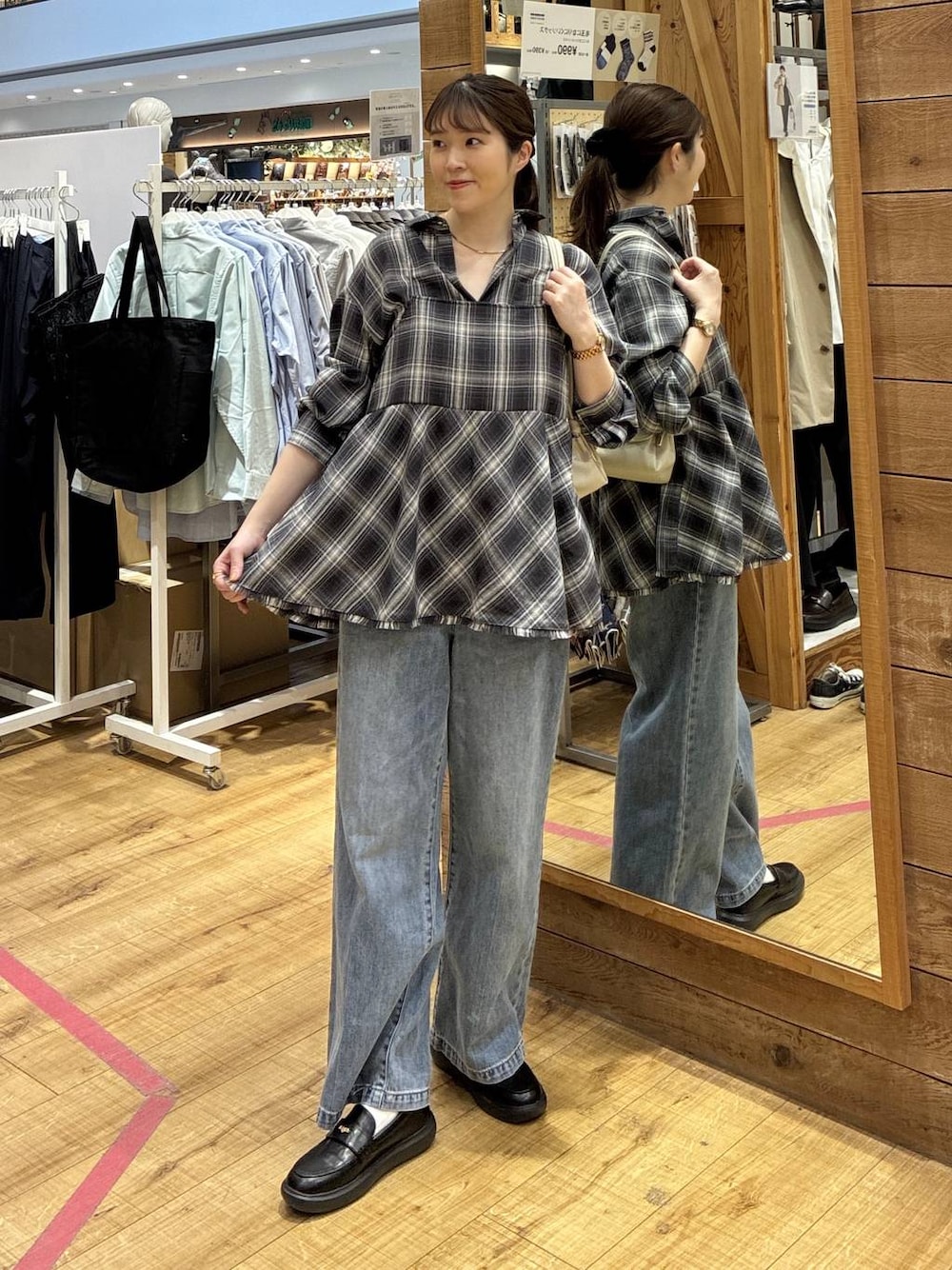 ブルー系のデニムパンツ、ベージュ系のショルダーバッグ、ブラック系のシャツ/ブラウスを着用したレディースの春コーディネートの1枚目の写真