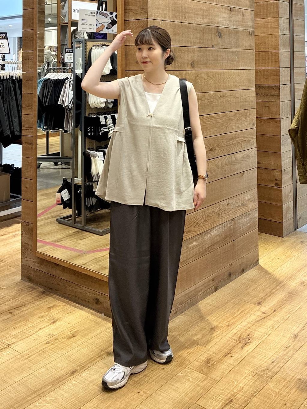 グレー系のスニーカー、ベージュ系のベスト、ブラウン系のその他パンツを着用したレディースの夏コーディネートの1枚目の写真