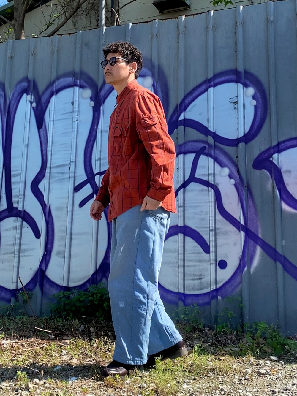 オレンジ系のシャツ/ブラウス、ブルー系のデニムパンツ、ブラウン系のドレスシューズを着用したメンズの春コーディネートの1枚目の写真