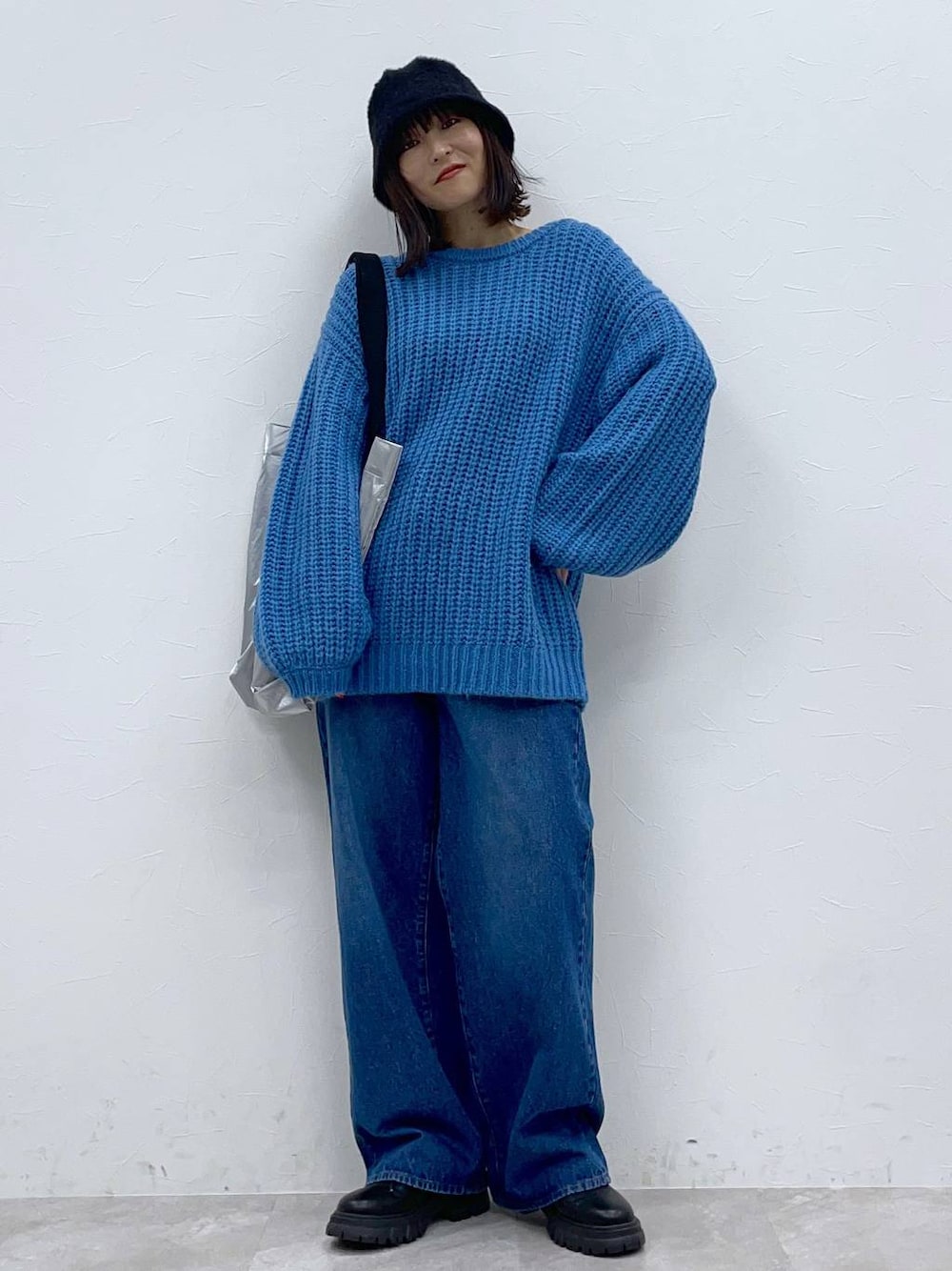 ブラック系のブーツ、ブルー系のデニムパンツ、シルバー系のトートバッグを着用したレディースの秋コーディネートの1枚目の写真