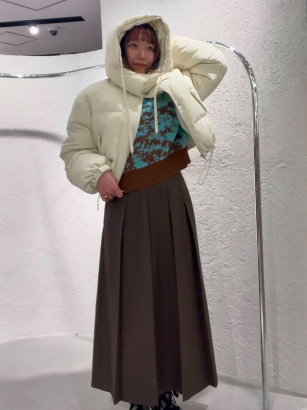 ホワイト系のダウンジャケット/コート、ブラウン系のニット/セーター、ブラウン系のワンピースを着用したレディースの冬コーディネートの1枚目の写真