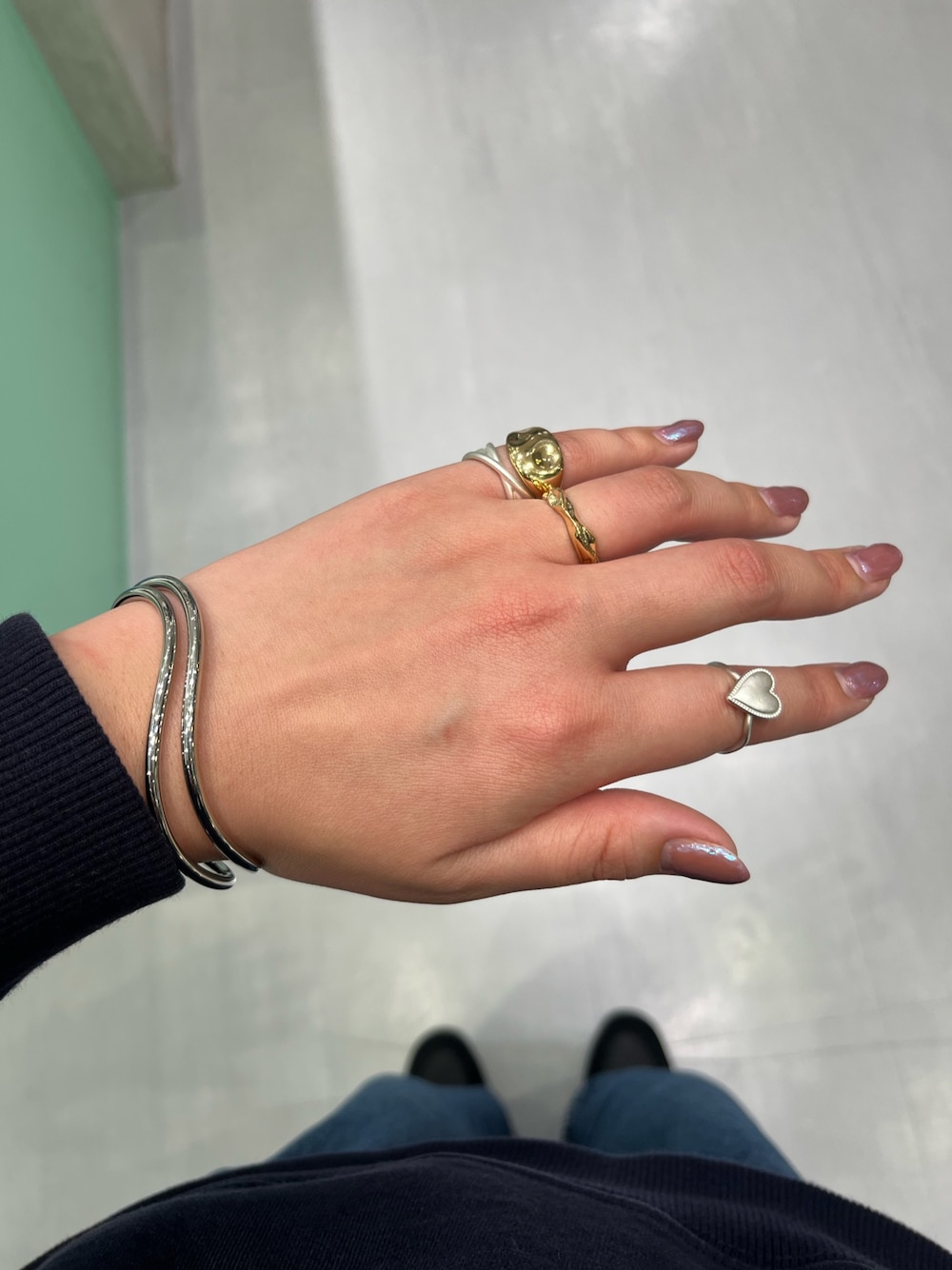 ゴールド系のリング、シルバー系のリング、シルバー系のブレスレットを着用したレディースの冬コーディネートの1枚目の写真