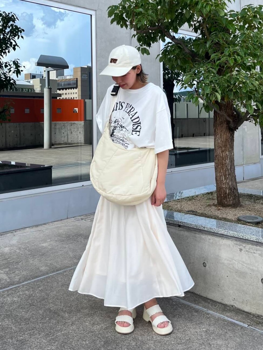 ホワイト系のサンダル、ホワイト系のショルダーバッグ、ホワイト系のTシャツ/カットソーを着用したレディースの夏コーディネートの1枚目の写真