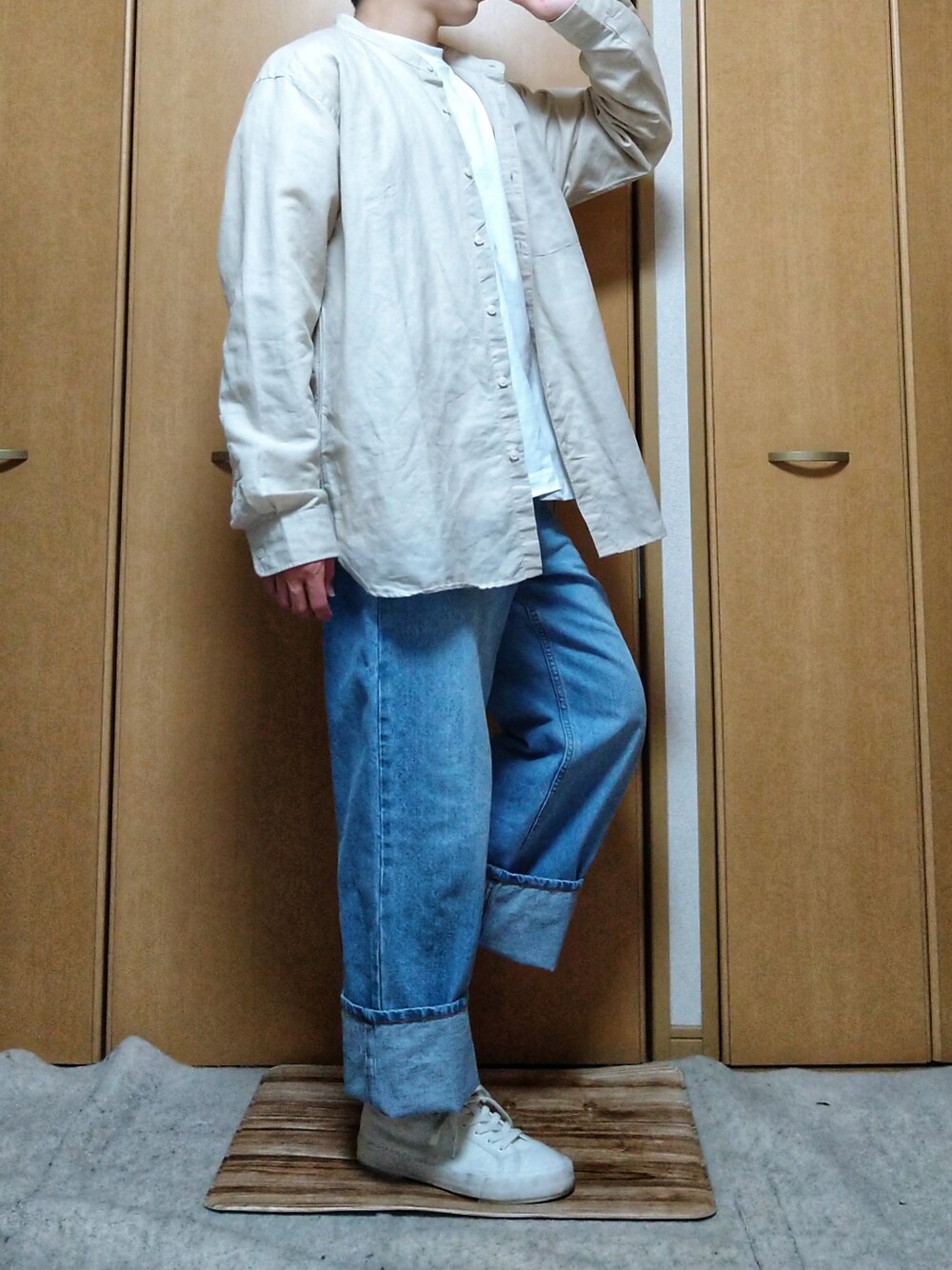 ブルー系のデニムパンツ、ホワイト系のスニーカー、ホワイト系のTシャツ/カットソーを着用したメンズの春コーディネートの1枚目の写真