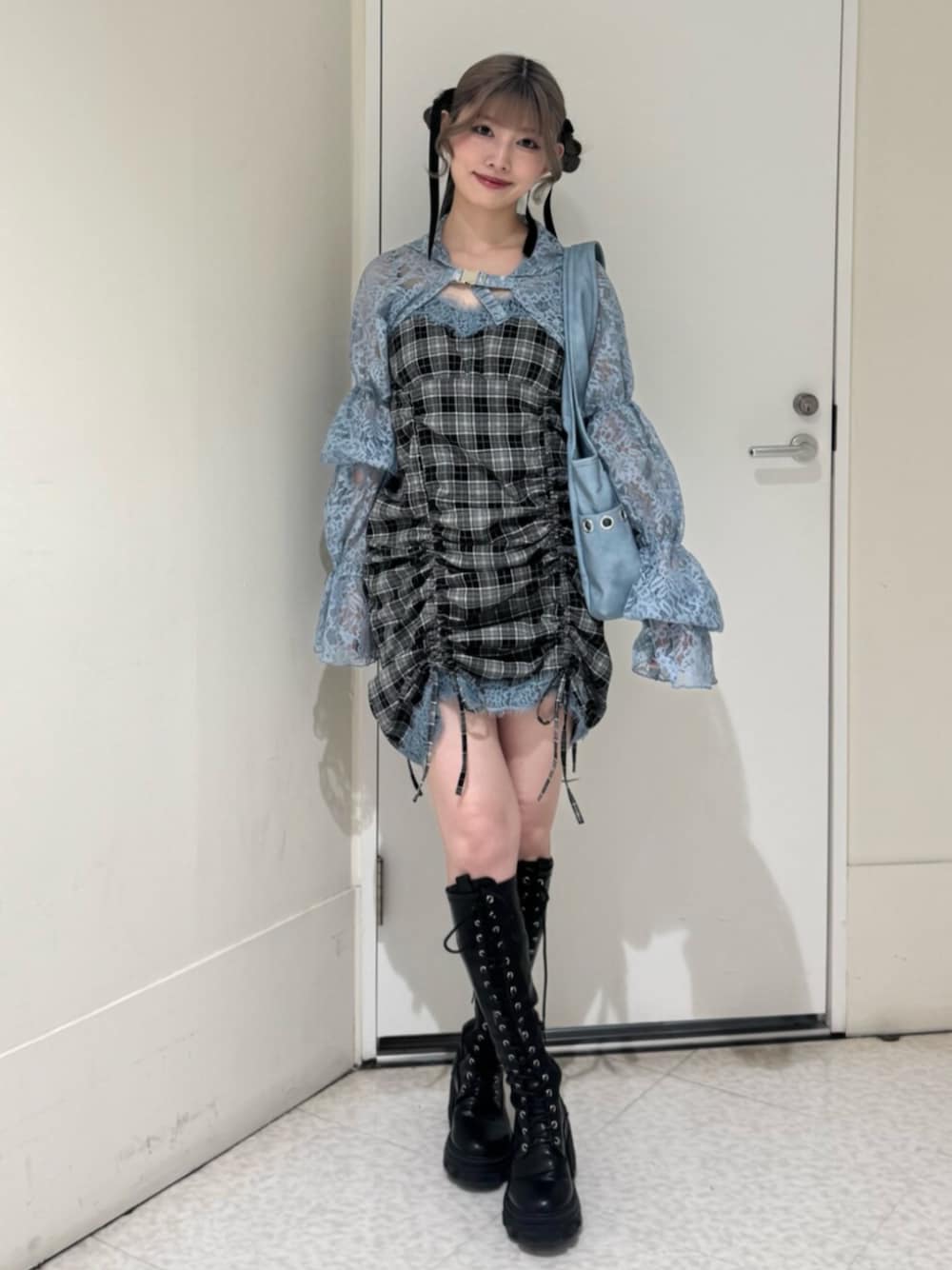 ブラック系のブーツ、ブルー系のカーディガン/ボレロ、ブルー系のトートバッグを着用したレディースの春コーディネートの1枚目の写真