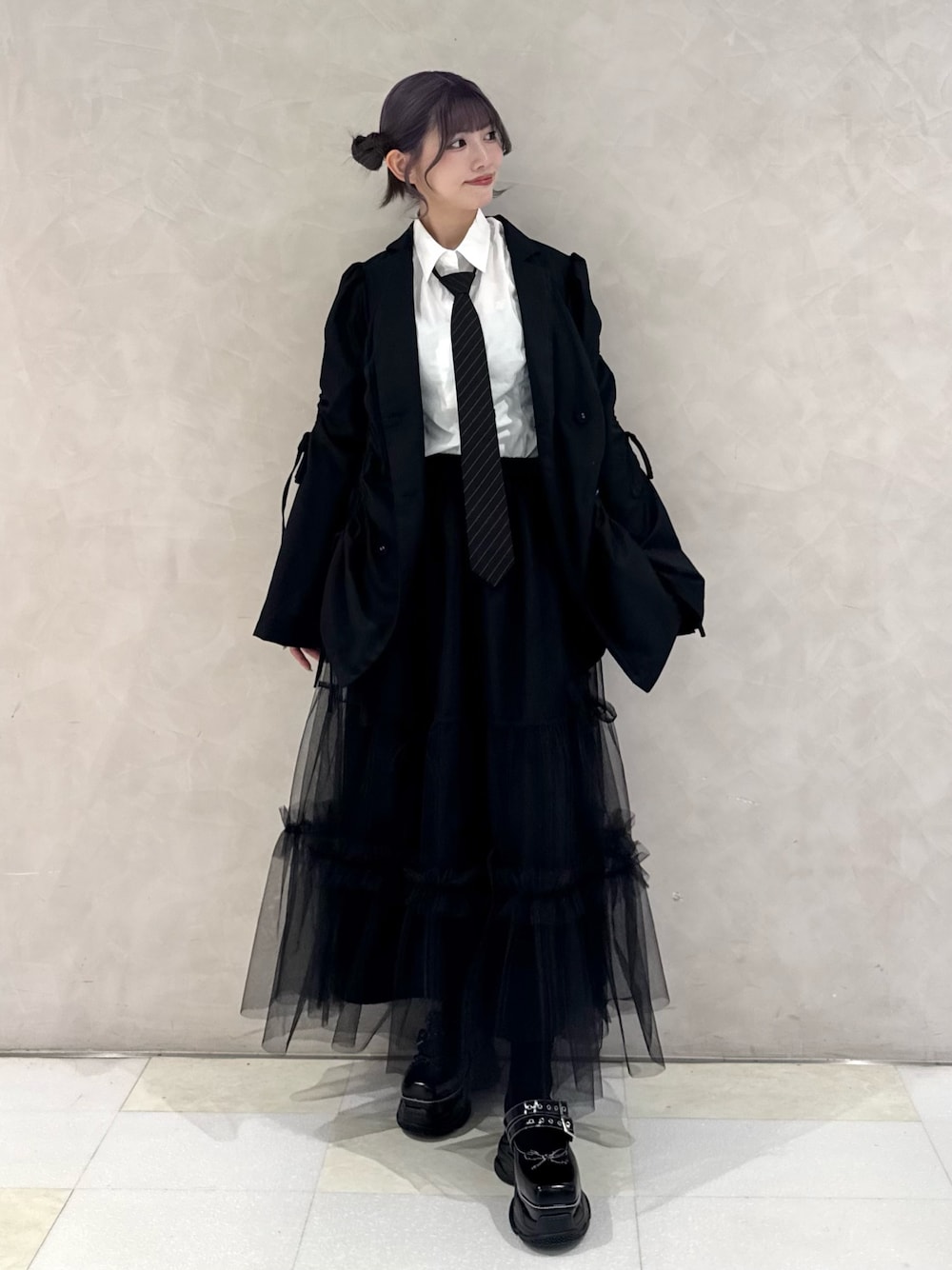 ブラック系のテーラードジャケット、ホワイト系のシャツ/ブラウス、ブラック系のネクタイを着用したレディースの秋コーディネートの1枚目の写真